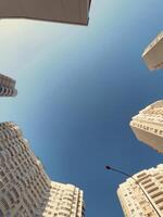 Skyward view of modern architecture capturing the essence of urban life during a sunny day photo