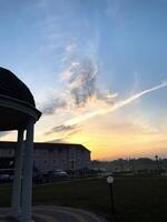 Sunrise over tranquil landscape with soft clouds painting the sky near a cozy resort photo