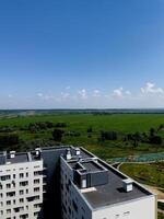 con vista a vibrante verde campos y moderno arquitectura debajo un brillante azul cielo en un sereno urbano paisaje foto