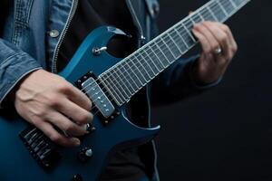 Skilled musician performs with electric guitar wearing denim jacket against dark background photo