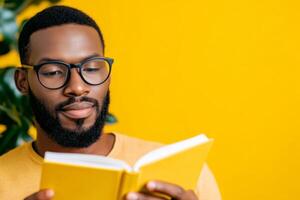 Man reading a yellow book against a bright yellow background in a cozy indoor setting photo