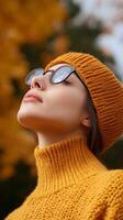 Woman in stylish yellow outfit enjoys autumn weather surrounded by vibrant foliage photo