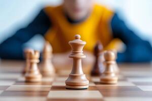 Young chess player focuses on the king piece during an intense match in a bright room photo