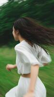 Young woman running through a green meadow with flowing hair on a sunny day in a natural setting photo