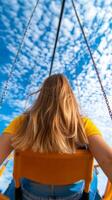 Enjoying a sunny day on a swing under a vibrant blue sky filled with fluffy clouds at a local park photo