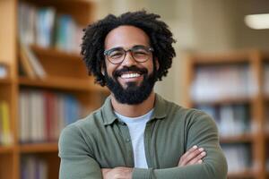 Smiling man with glasses poses confidently in a library setting during daytime photo