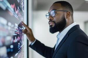 Professional man analyzing financial data on a digital display in a modern office setting photo