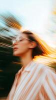 Woman in oversized glasses captured in motion during sunset at a park with blurred background showing warm colors photo