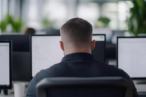 Office worker focused on computer screens in a modern workspace during the day, showcasing productivity and technology photo