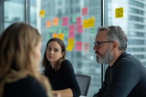 Meeting with team members discussing project ideas in a modern office environment during daylight hours photo