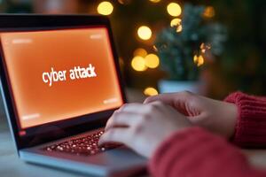 Individual typing on a laptop displaying a warning about a cyber attack while sitting in a cozy environment with bokeh lights photo