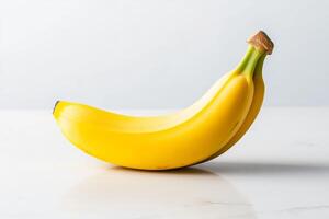Yellow bananas resting on a clean white surface showcasing their smooth texture and vibrant color photo