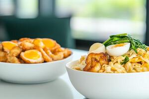 Delicious noodle dish with grilled chicken and soft-boiled eggs served in a cozy restaurant setting photo