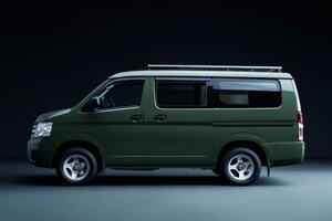 Green van parked in a dark studio, showcasing its sleek design and modern features, ideal for adventure and travel enthusiasts photo
