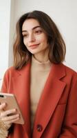 Young woman in a stylish outfit engaged with her smartphone indoors during daylight hours photo