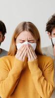 People wearing masks showing distress while experiencing discomfort in a neutral indoor photo