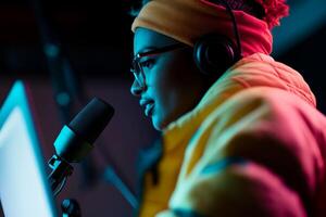 Young person streaming live from a cozy studio during evening hours with vibrant lighting and focused expression photo