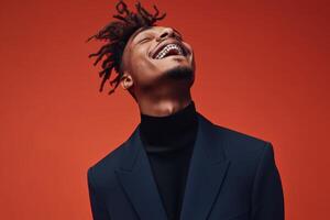 Smiling man with dreadlocks wearing a navy suit against a vibrant red background exuding confidence and joy photo