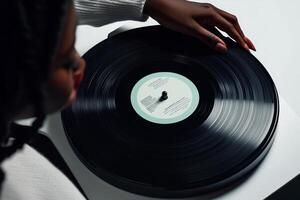 Enjoying the music while placing a vinyl record on the turntable in a cozy indoor setting photo