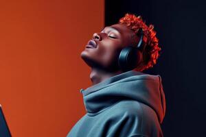Young man enjoying music with headphones in a modern, colorful setting during the evening hours photo