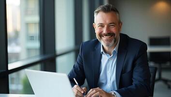 Flat Middle aged smiling professional businessman and CEO wearing suit sitting at desk in modern office working on laptop and writing notes with copy space for text concept as Mid Realistic Set 2 photo