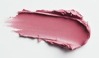 a close up of a pink lipstick on a white surface. photo