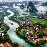 Stunning aerial panorama of a small village on the banks of the Li River, enveloped by misty karst mountains in a tranquil landscape photo