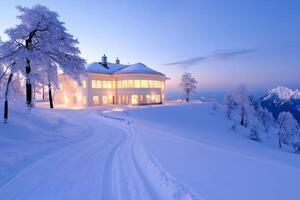 Illuminated mountain hotel surrounded by snow covered trees at dusk photo