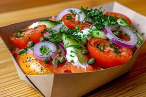 Bagel with cream cheese, smoked salmon, tomatoes, cucumbers, capers, red onions and dill photo