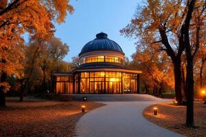 Illuminated pavilion surrounded by colorful autumn trees in a park at dusk photo