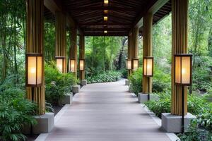 Covered walkway with bamboo columns and illuminated japanese lanterns leading to a peaceful green garden photo