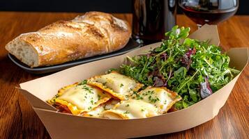 Delicious ravioli with melted cheese, fresh salad and baguette accompanied by red wine photo