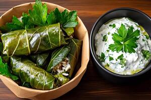 Stuffed Grape Leaves with Yogurt and Parsley Sauce on Wooden Table photo