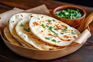 Delicious indian flatbread paratha garnished with fresh coriander leaves in a bowl photo