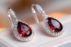 Beautiful earrings with red garnet and diamonds shining on soft background photo
