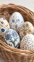 Easter eggs with hand-painted floral ornaments resting in a wicker basket photo