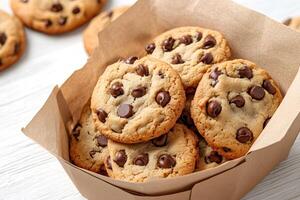 Freshly baked chocolate chip cookies stacked in a paper container, photo