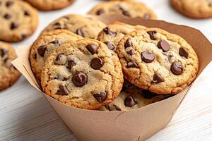 Freshly baked chocolate chip cookies stacked in a paper container. photo
