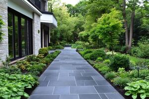 Paved pathway leading through a lush garden by a modern house photo