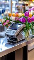 Pos terminal waiting for payment in a flower shop with colorful tulips photo