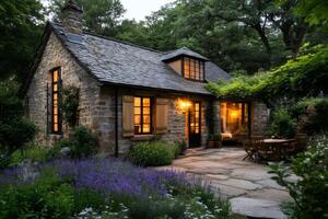 Charming stone cottage illuminating the twilight with warm lights and surrounded by lavender field photo