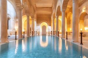 Ancient reflecting in turquoise water surrounded by columns and torches photo