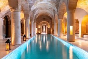 Tranquil indoor swimming pool illuminated with warm light in ancient building photo
