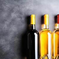 Trio of beautifully designed wine bottles arranged perfectly together on a wooden surface in a bar photo