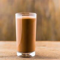 A glass of chocolate milk on a wooden table photo