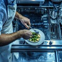 A man in a white apron is cooking food on a plate photo