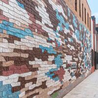 A brick wall with multicolored paint on it photo
