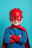 Superhero kid smiling with crossed arms on blue background photo