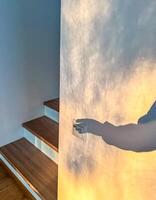 Shadow Hand Turning on Light Switch by Stairs, Interior Scene, Light and Shadow Play, Home. High quality photo