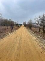 Empty Dirt Road Through Rural Landscape, Cloudy Sky, Natural Scenery, Travel, Remote Location. High quality photo